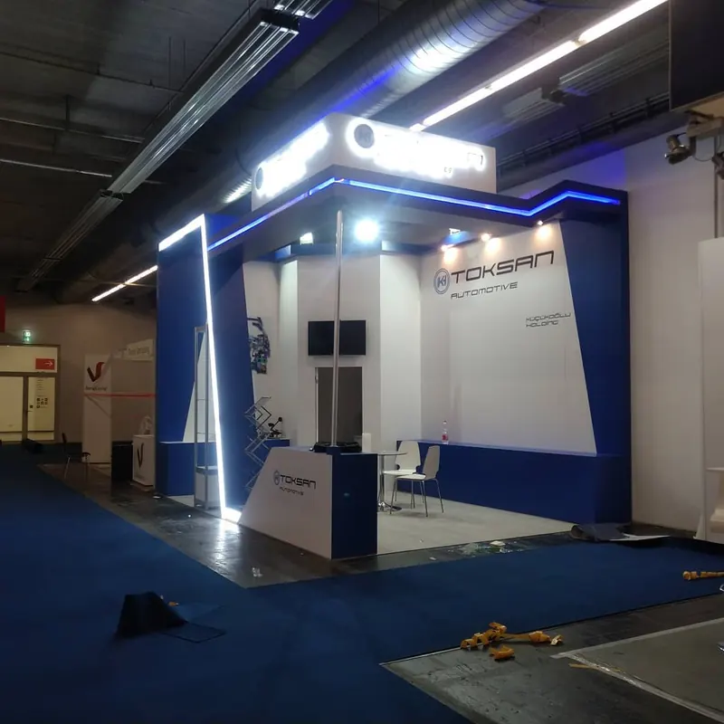Blau-weißer Messestand mit blau beleuchtetem Portal und kleiner Empfangstheke.