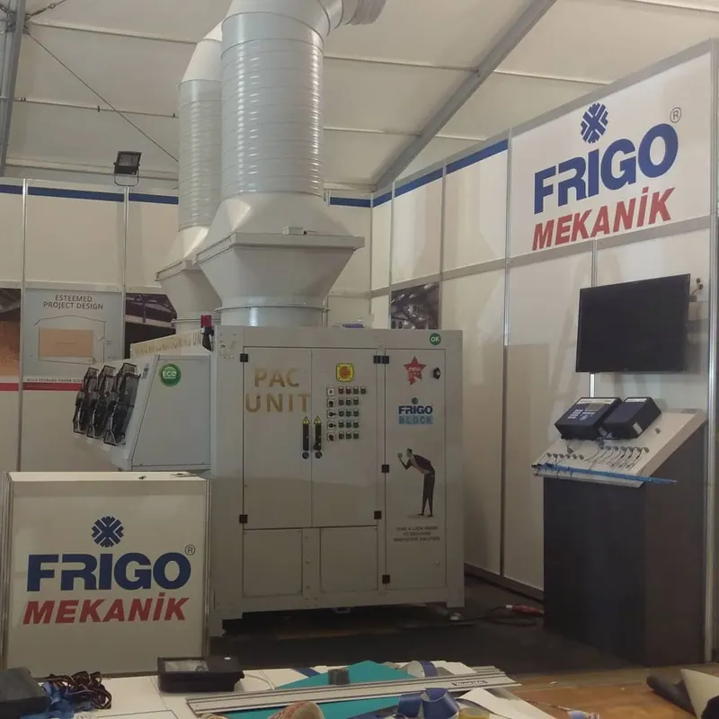 Weißer Messestand mit großen grauen Technikgehäusen und silbernem Lüftungsrohr.