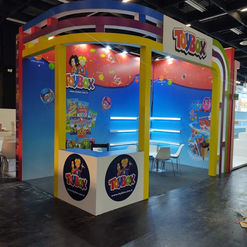 Bunter Messestand mit mehrfarbigen Portalbögen, blauen Wänden und Produktbildern.