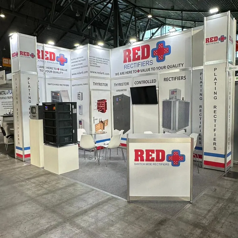 Weißer Messestand mit roten Produktgrafiken, Glasvitrinen und Empfangstheke.