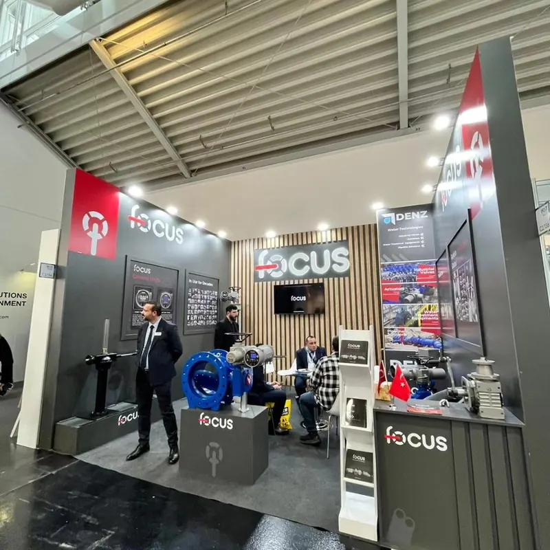Grau-roter Messestand mit beleuchteten Lamellen, Produktpodesten und Besuchern.