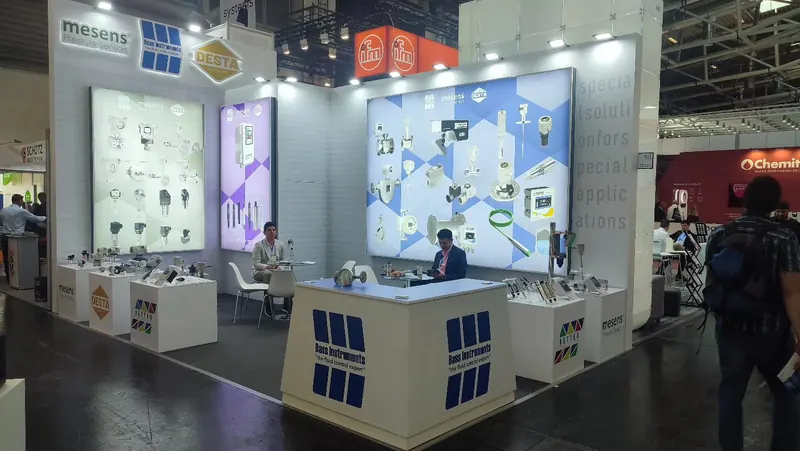 Heller Messestand mit großen Technikgrafiken und mehreren weißen Produktpodesten.