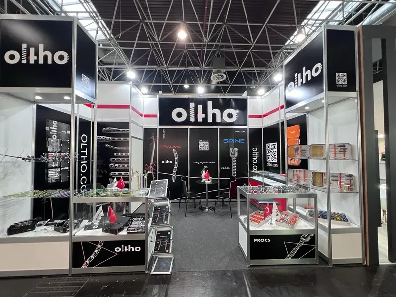 Schwarz-weißer Messestand mit hohen Rahmen und mehreren Glasvitrinen.