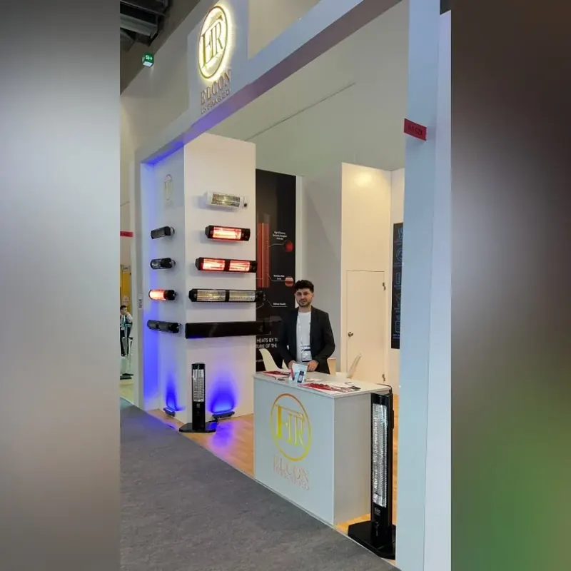 Heller Messestand mit beleuchtetem Portal und rechteckigen Leuchtenmustern an einer Wand.