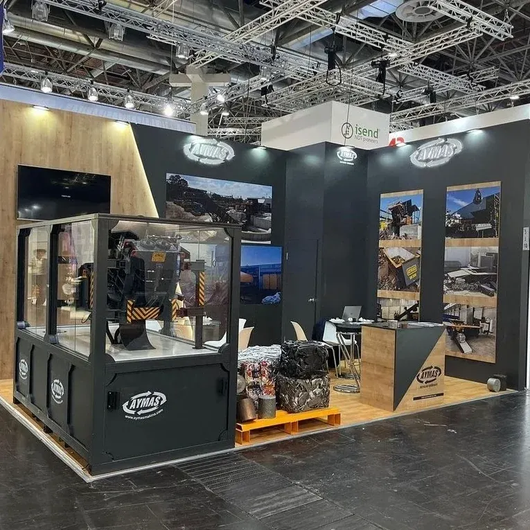 Dunkler Messestand mit Glasvitrinen, großformatigen Fotografien und Materialmustern.