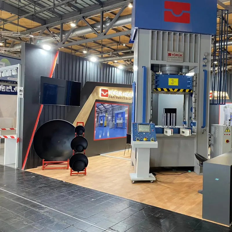 Messestand mit Holzoptikboden, hoher grauer Struktur und großen Metallbauteilen.