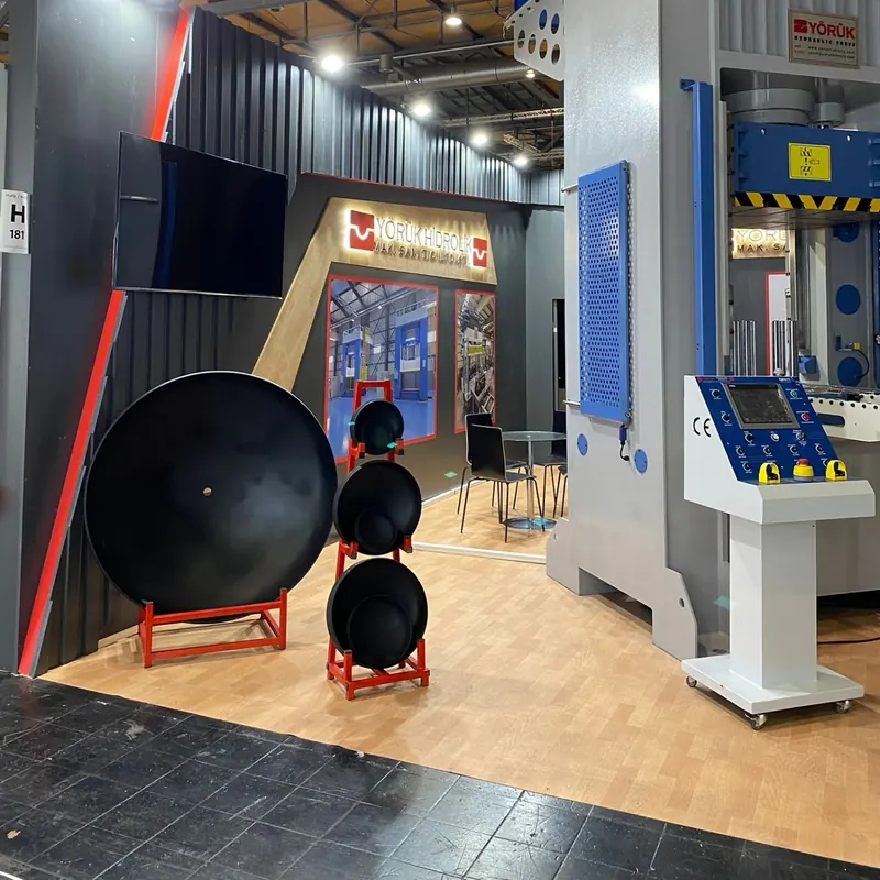 Schwarz-roter Messestand mit großen runden Exponaten und weißer Bedieneinheit.