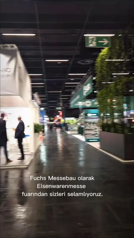 Reel-Vorschaubild: Hallengang zwischen Messeständen mit Pflanzen und Personen.
