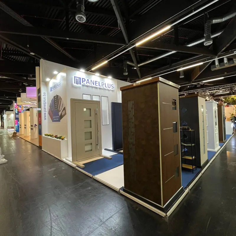 Messestand mit nebeneinander ausgestellten Türen, weißen Standwänden und blauen Bodenflächen.