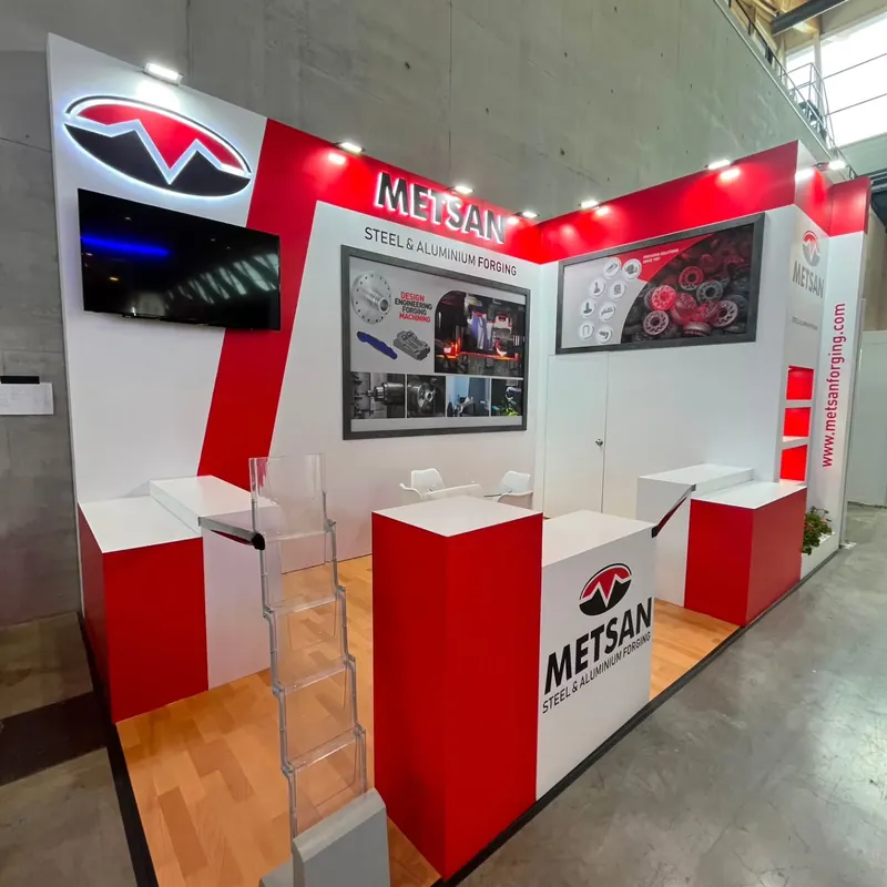 Rot-weißer Messestand mit Bildschirm, weißen Thekenplatten und Holzboden.