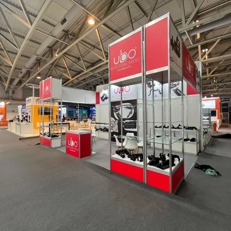 Messestand mit hohen rot-weißen Wänden und verglasten Produktvitrinen.